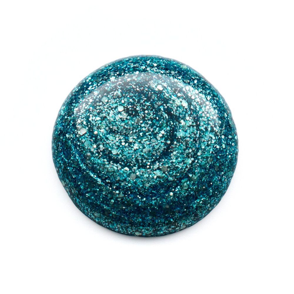 Goutte de vernis à ongles bleu pailleté. Forme ronde. Sur fond blanc.