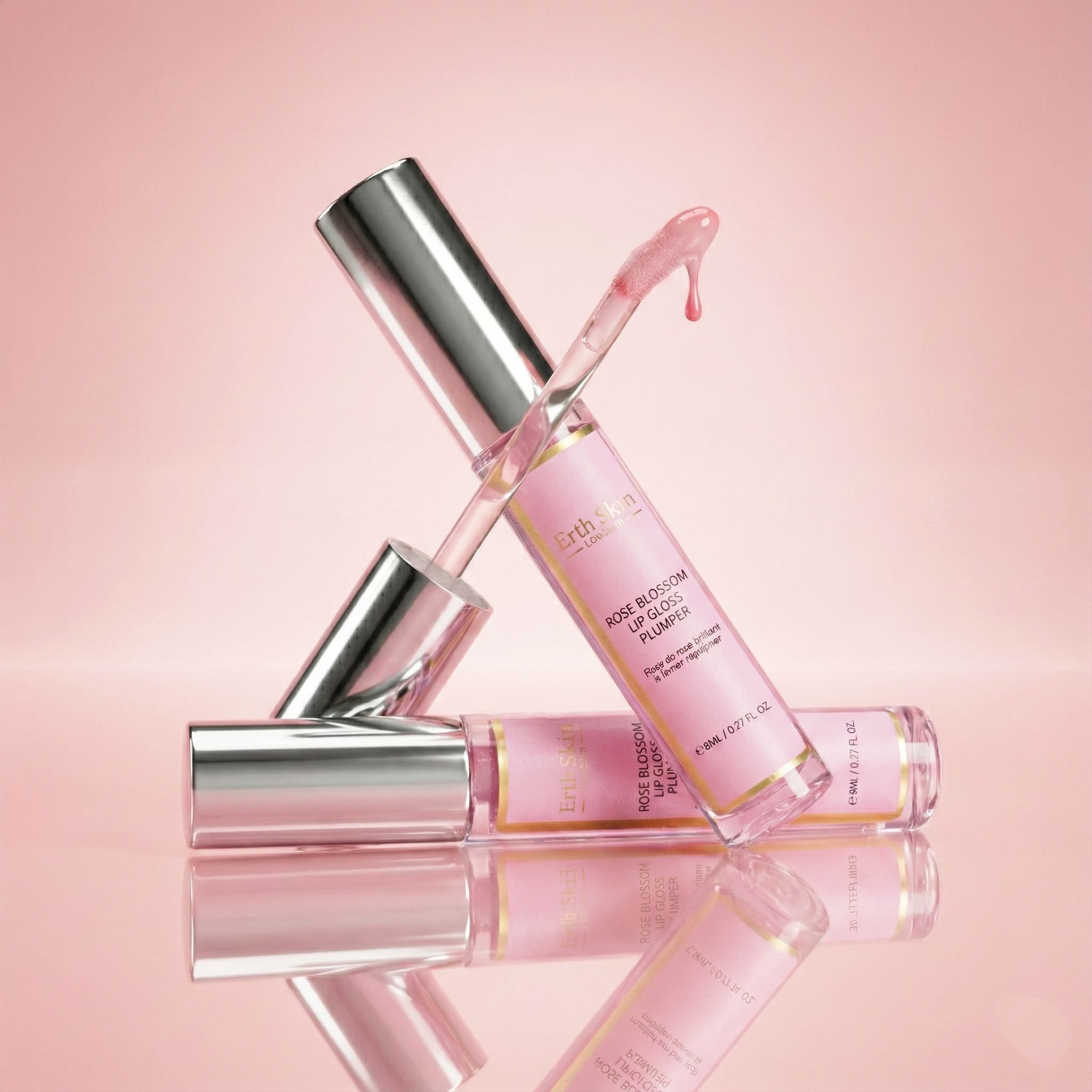 Twee lipglosses met zilveren doppen. Roze vloeistof. Eén ligt, één staat. Roze achtergrond.