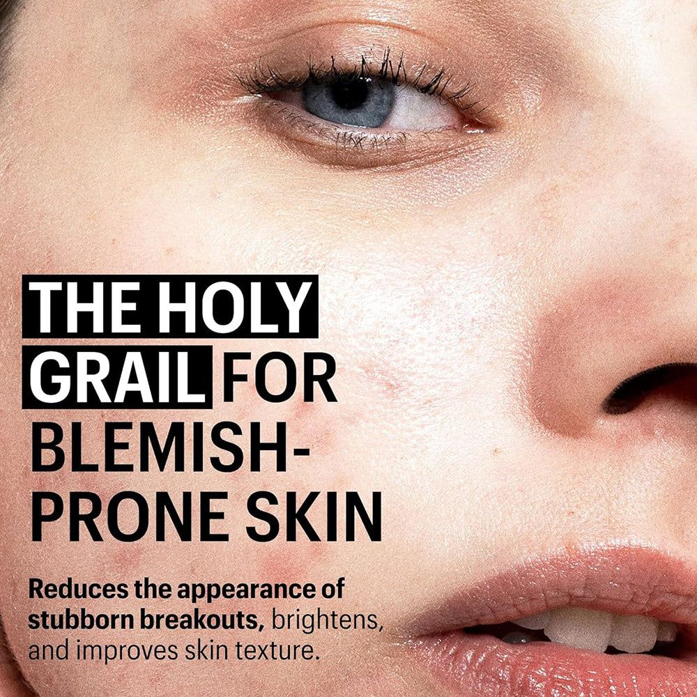 Gros plan d'un visage avec texte : « THE HOLY GRAIL FOR BLEMISH-PRONE SKIN ». Texte en dessous : Réduit les imperfections, illumine.