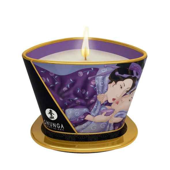 Shunga massagekaars met erotische kunst, brandend op een gouden onderzetter.