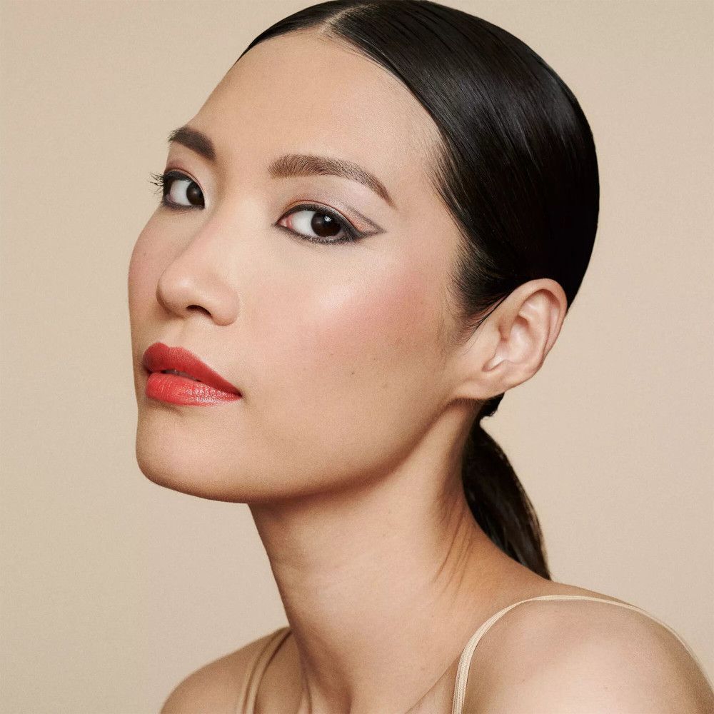 Portrait d'une femme à la peau claire. Elle porte un trait de khôl noir sur l'œil.