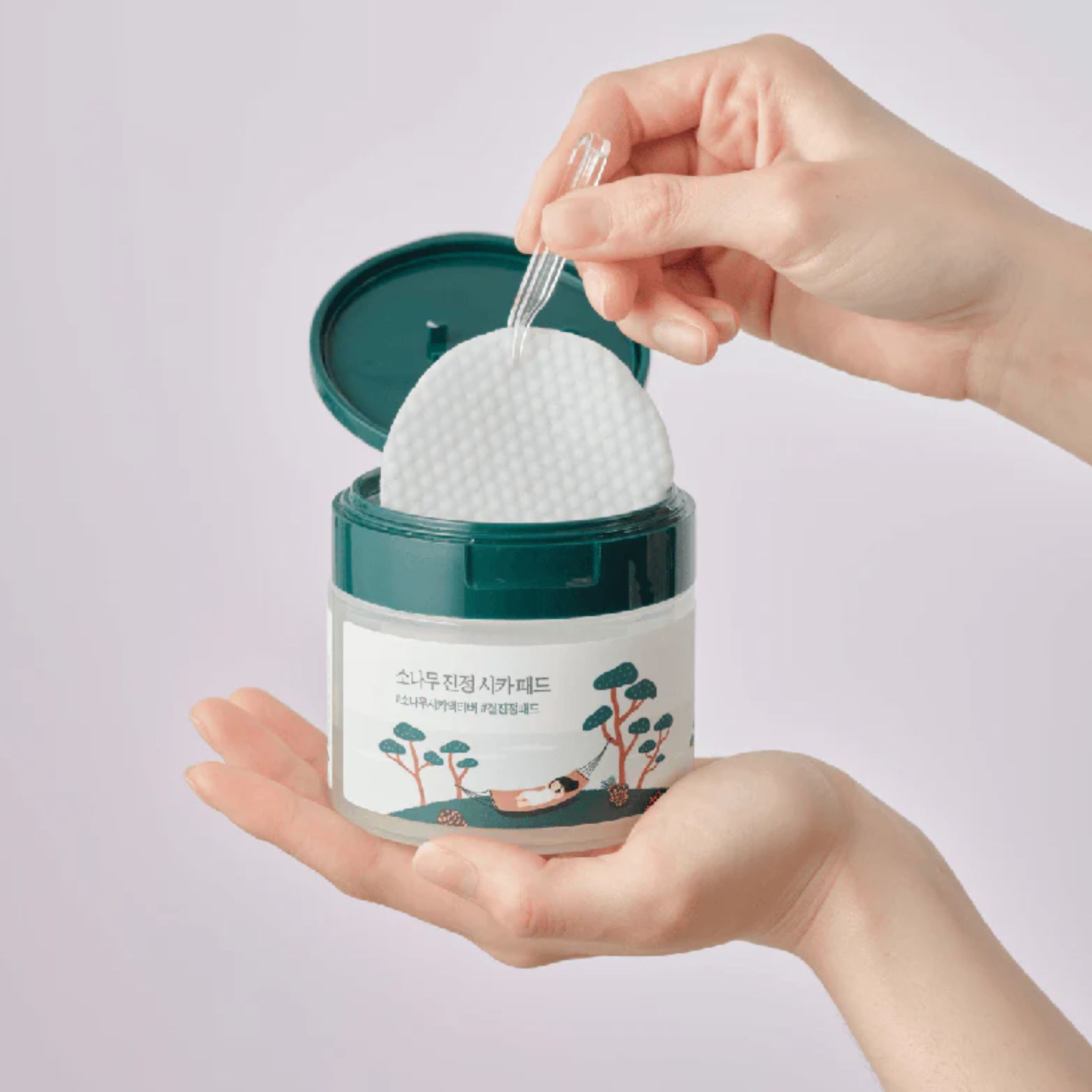 Round Lab Lab Pine Calming Cica Pad: hand pakt pad met pincet uit pot.