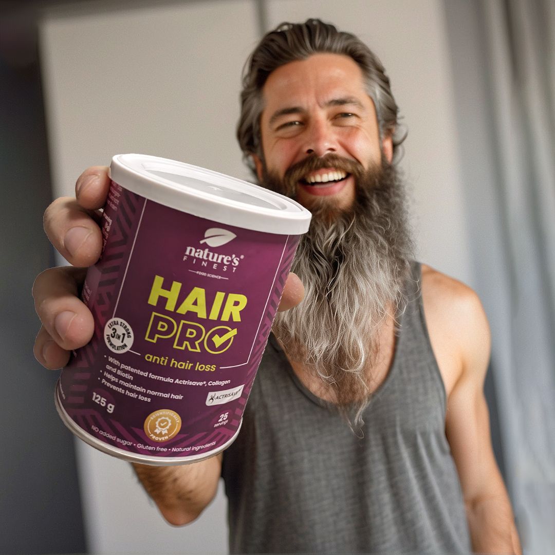 Man houdt pot Nature's Finest Hair Pro vast. Opschrift: Hair Pro, tegen haaruitval. 125g, 25 porties. Baard.