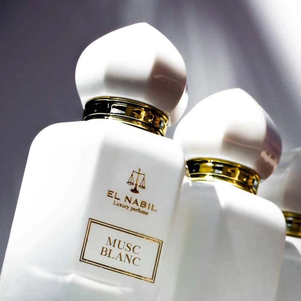 Deux flacons de parfum blancs, détails dorés, bouchons blancs. Inscription: Musc Blanc, El Nabil.