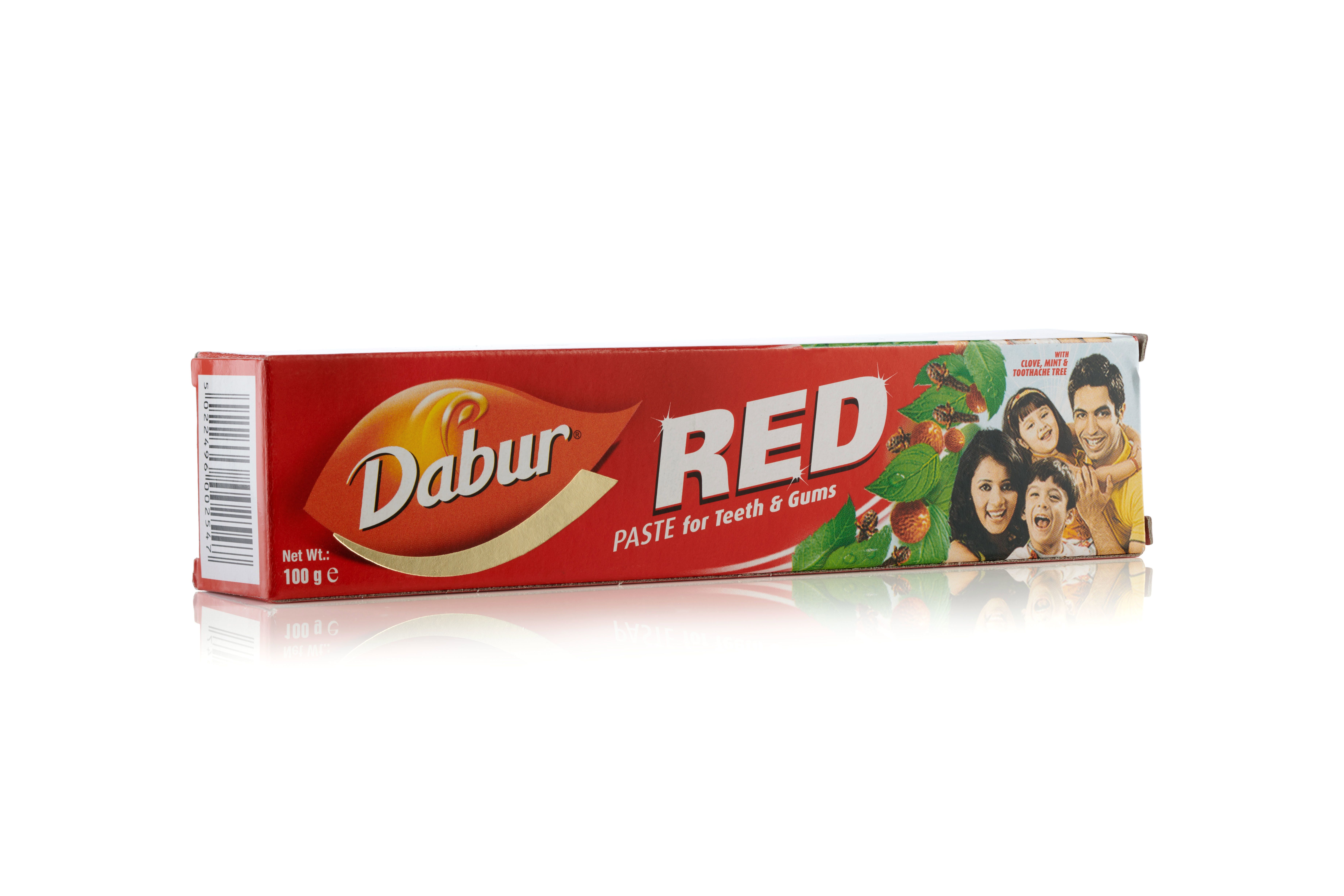 Tube et boîte de pâte dentifrice Dabur Red. Emballage rouge avec inscription blanche et jaune.