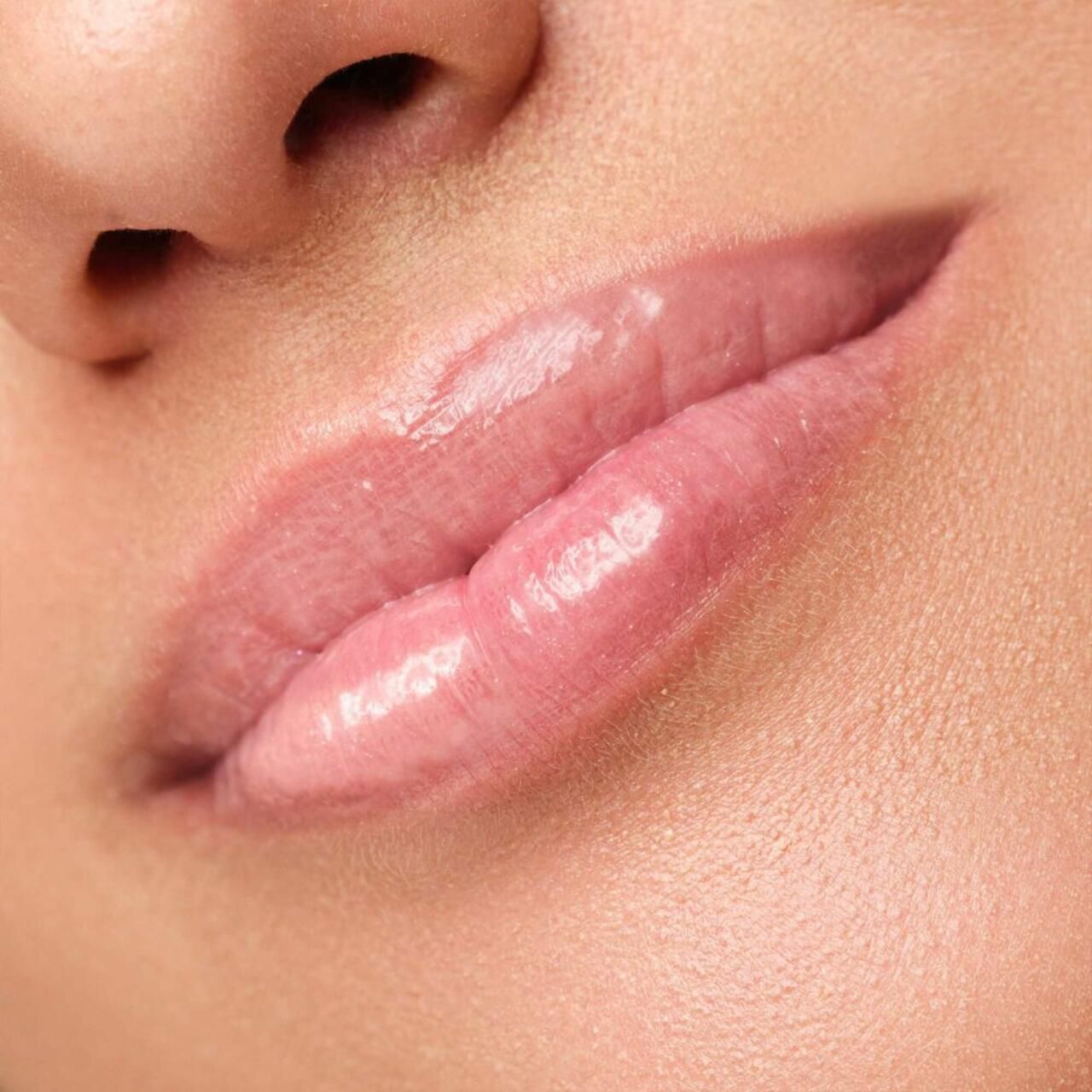 Close-up van lippen. Glanzende, roze lippenstift op de lippen.