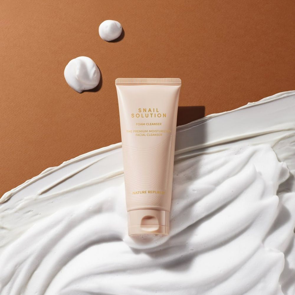 Tube beige avec texte et mousse. Taches de mousse sur fond marron.