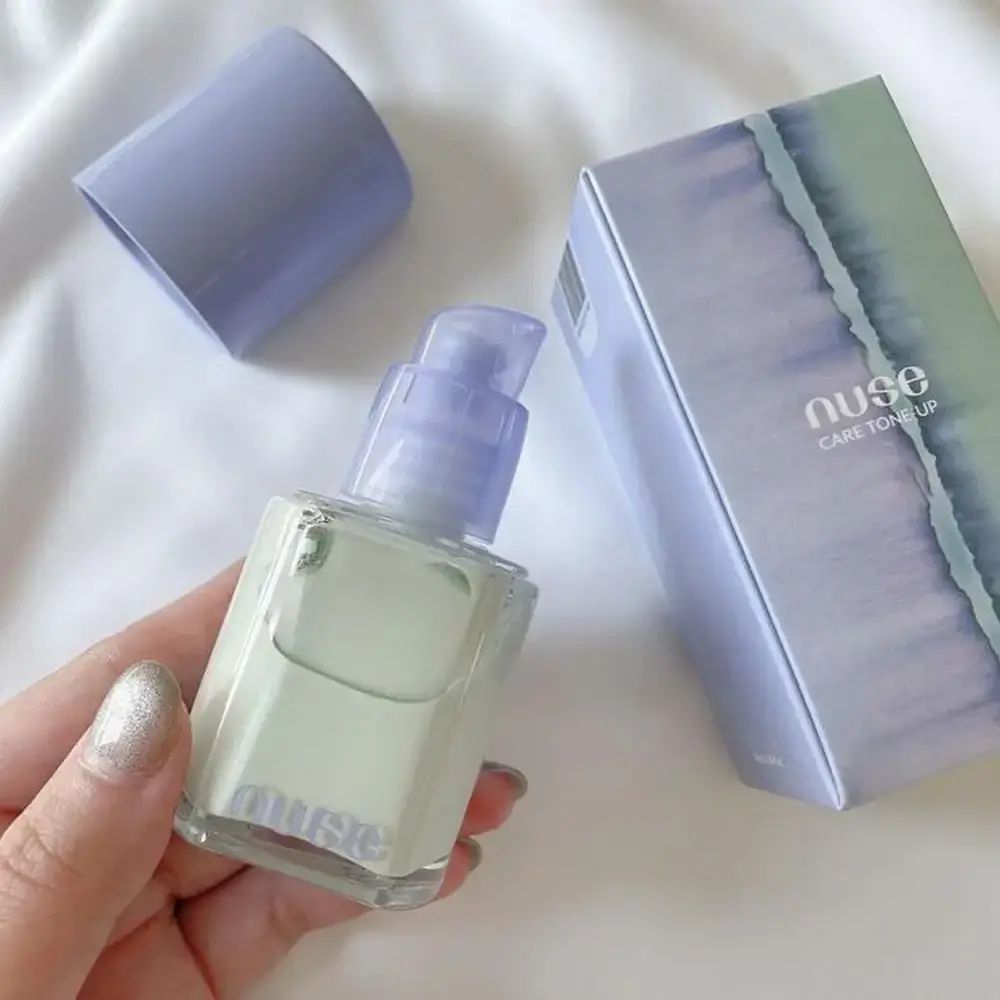 Make-up primer met pomp, paarse dop en doos. Merk Nuse.