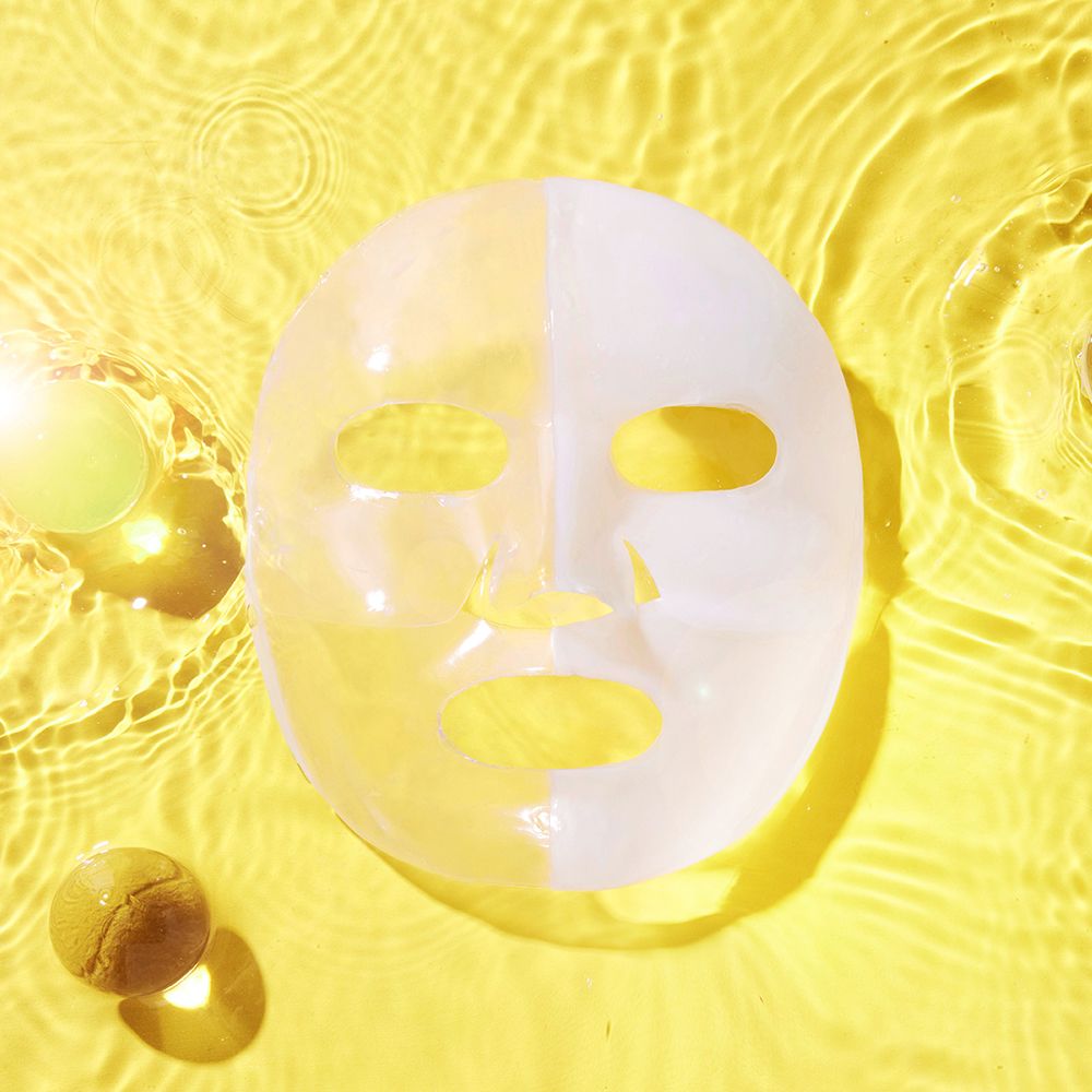 Advanced Snail Mucin Glass Glow Hydrogel Mask op gele achtergrond met watereffect.