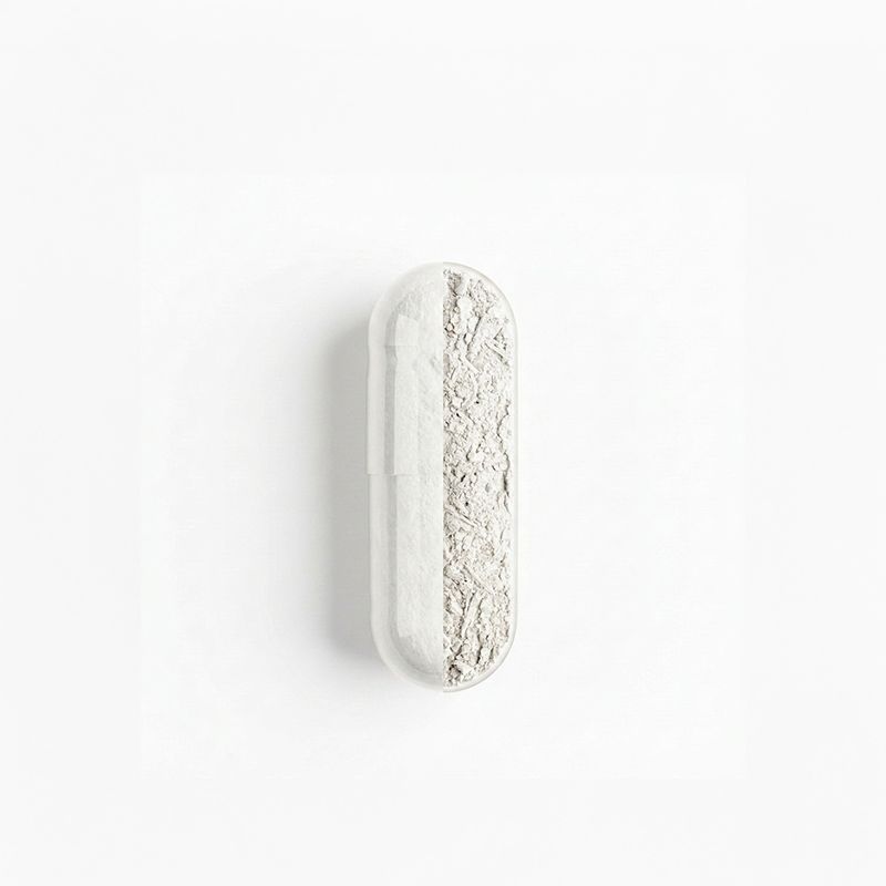 Une seule capsule, à moitié remplie de poudre blanche, sur fond blanc.