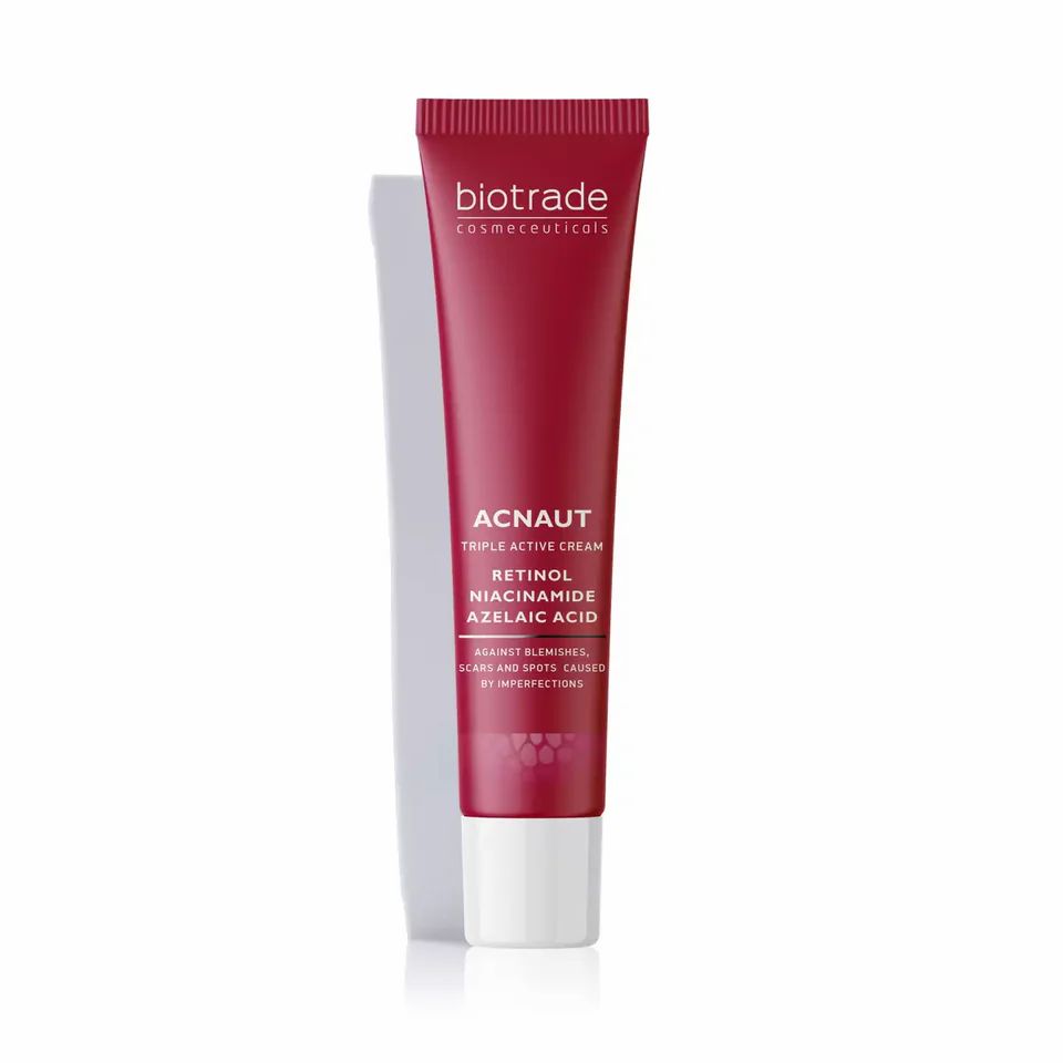 Tube rouge avec bouchon blanc. Texte: Biotrade, Acnaut Triple Active Cream. Contient du rétinol, de la niacinamide, de l'acide azélaïque. Fond blanc.