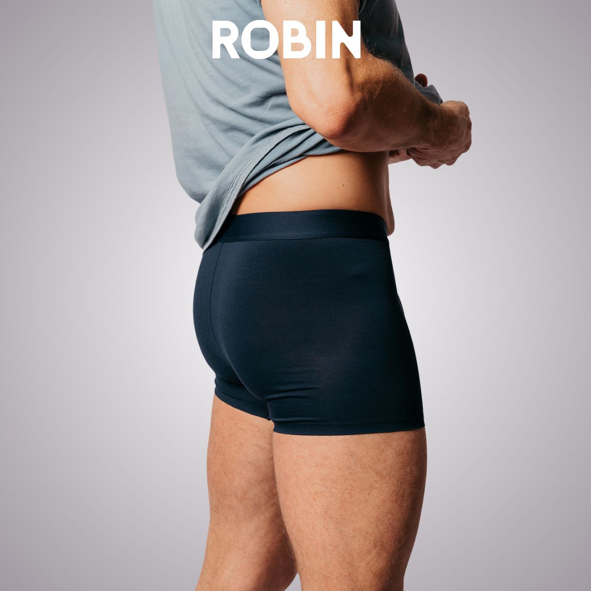 Achterkant van een donkerblauwe herenboxer, discreet gedragen onder kleding.