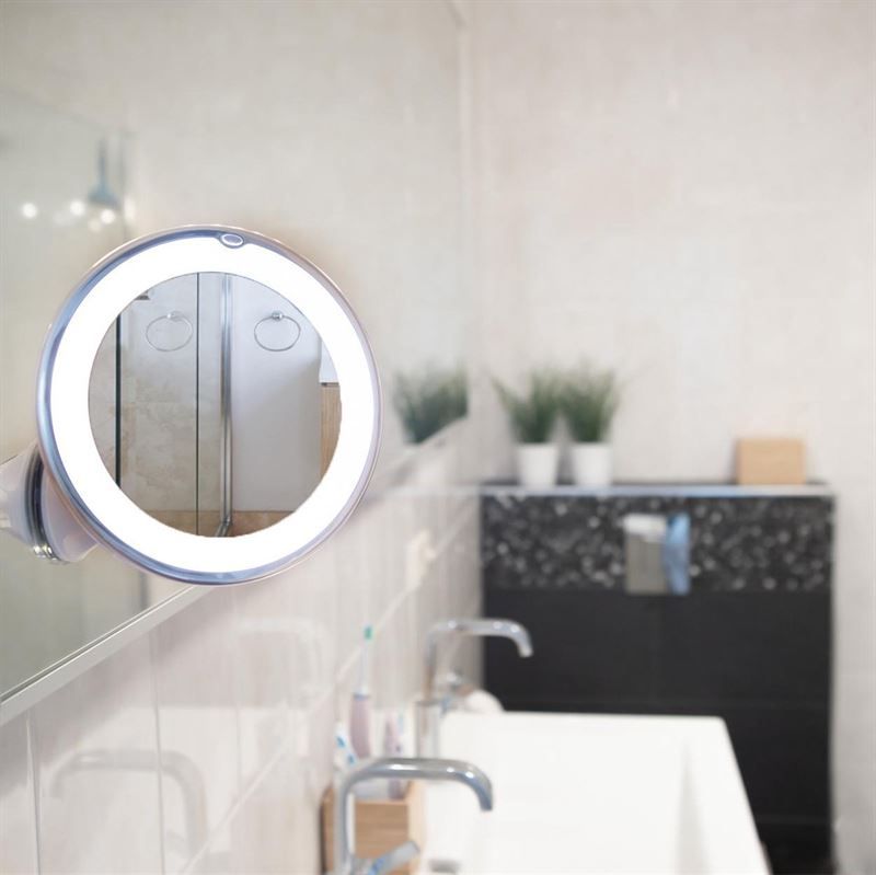 Miroir cosmétique rond avec éclairage LED et ventouse, fixé sur un miroir de salle de bain.