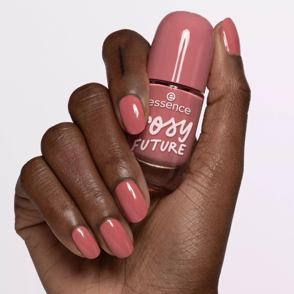 Main avec ongles vernis et flacon de vernis à ongles. Teinte : couleur des ongles. Inscription : essence rosy FUTURE.