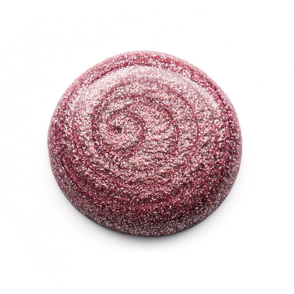 Tache ronde de vernis à ongles rose pailleté. Texture en spirale sur fond blanc.