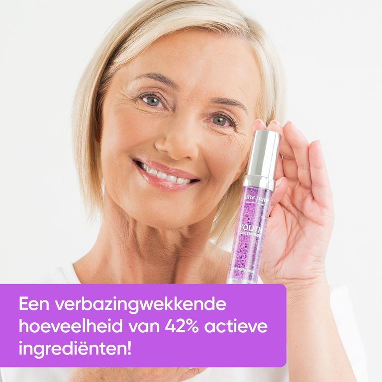Vrouw houdt flacon Youth Concentrate Serum vast, met tekst over percentage actieve ingrediënten.