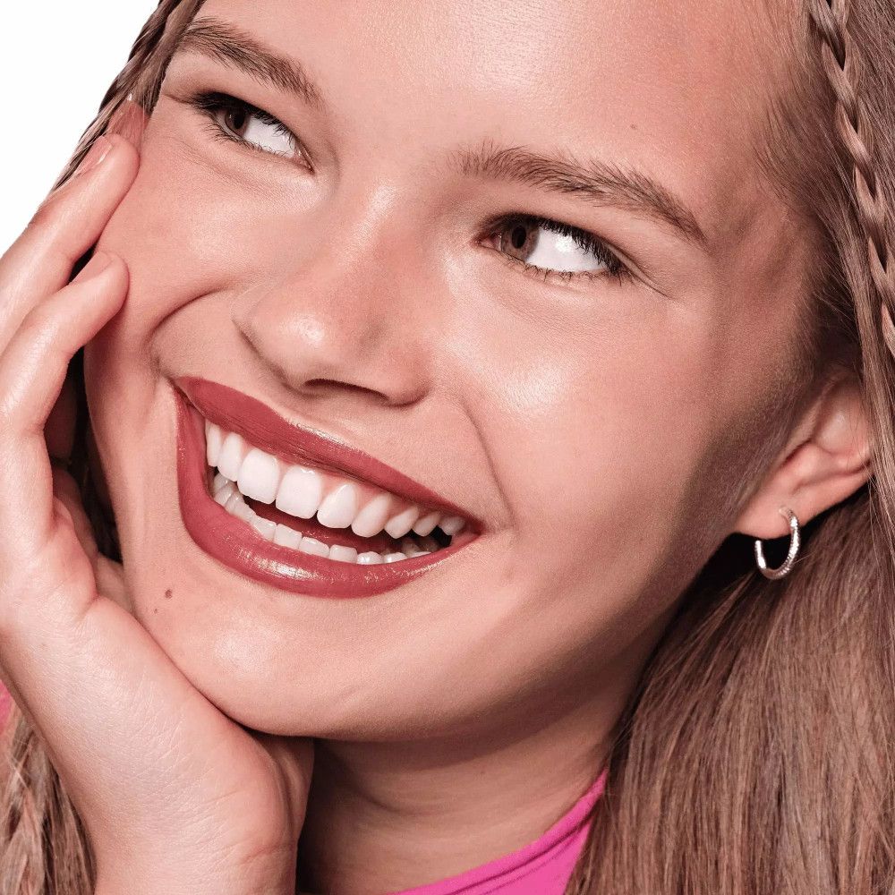 Portrait d'une femme souriante avec du rouge à lèvres. Rouge à lèvres foncé.