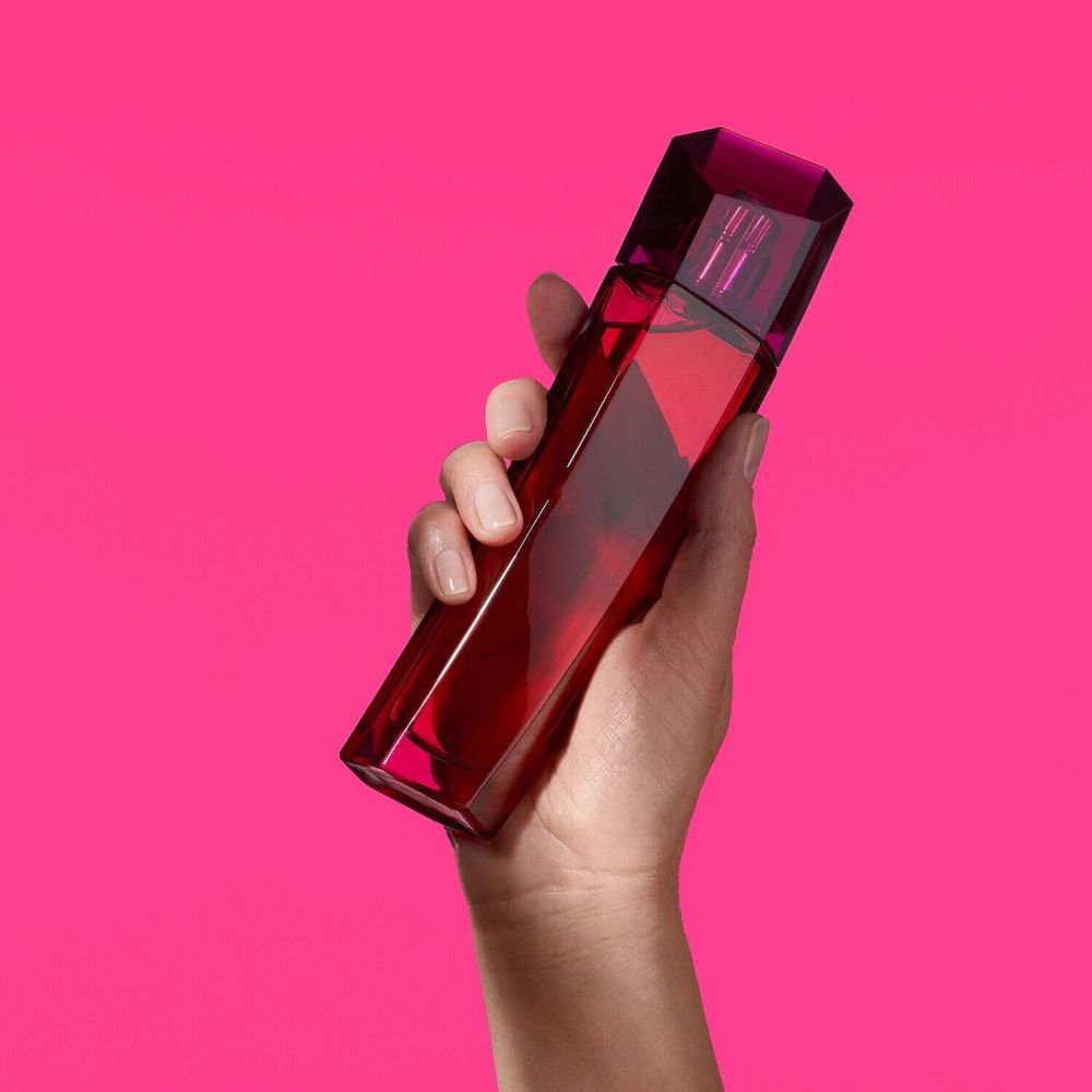 Main tenant le flacon Escada Magnetism Eau de Parfum.