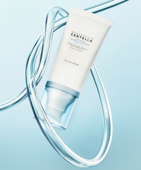 Witte tube Madagaskar Centella Hyalu-Cica Water-Fit Sun Serum, omringd door waterstromen.