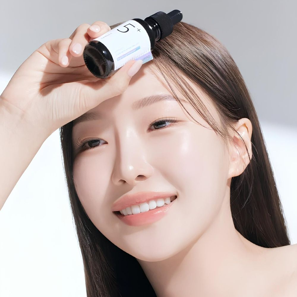 Femme tenant un flacon noir avec pipette. Étiquette avec texte: Vitamin Concentrated Serum, Glutathione. Inscription: 5+.