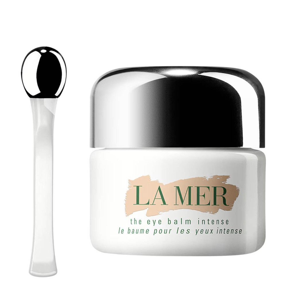 Un pot de baume pour les yeux et un applicateur. Le pot a un couvercle argenté. Sur le pot, "LA MER".