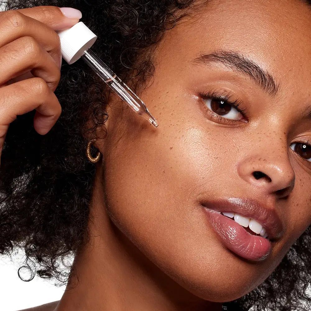 Vrouw met huidverzorgingsserum-applicator. Dichtbij gezicht, serum aangebracht.