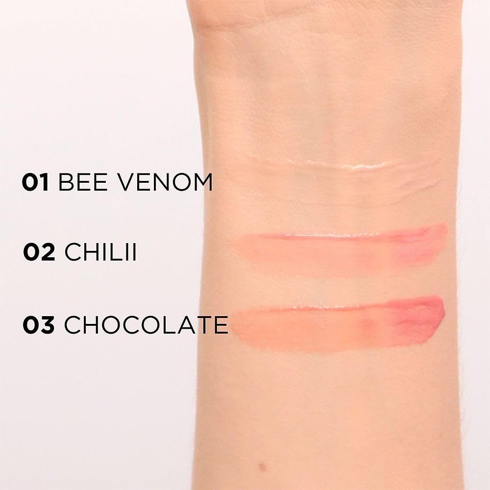 Avant-bras avec trois échantillons de gloss : 01 Bee Venom, 02 Chilii, 03 Chocolate. Texte à côté des échantillons.