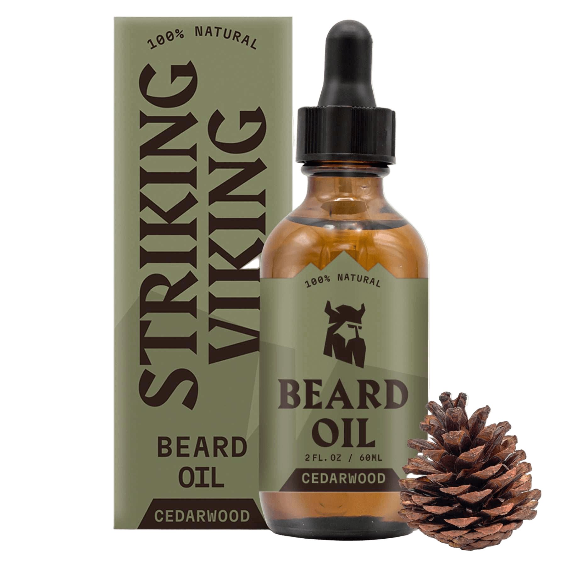 Flacon d'huile à barbe marron avec pipette, à côté d'un emballage et d'une pomme de pin. Inscription : "STRIKING VIKING BEARD OIL CEDARWOOD".