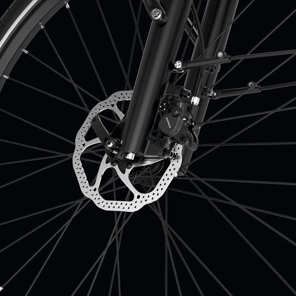 Close-up van de voorrem van een zwarte e-bike. Schijfrem met remklauw en spaken.