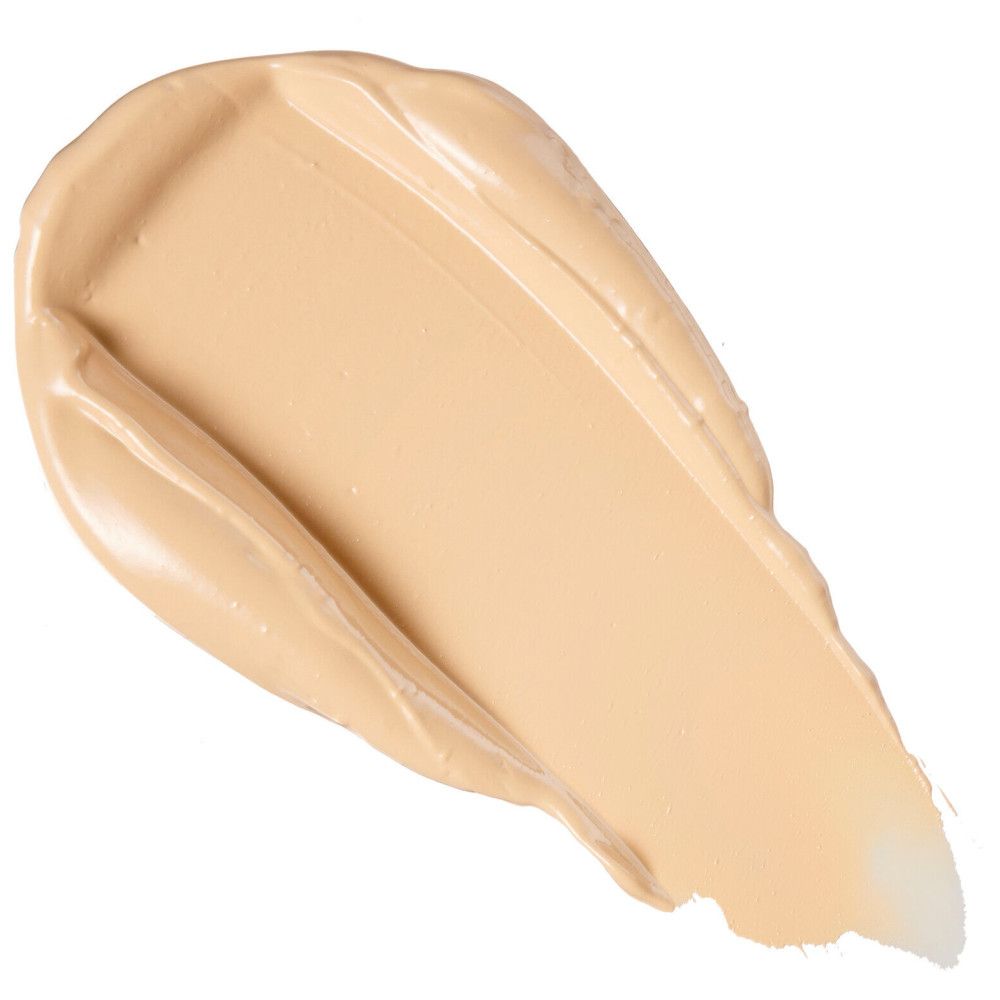 Nuance claire de correcteur sur fond blanc. Texture crème, forme diagonale.