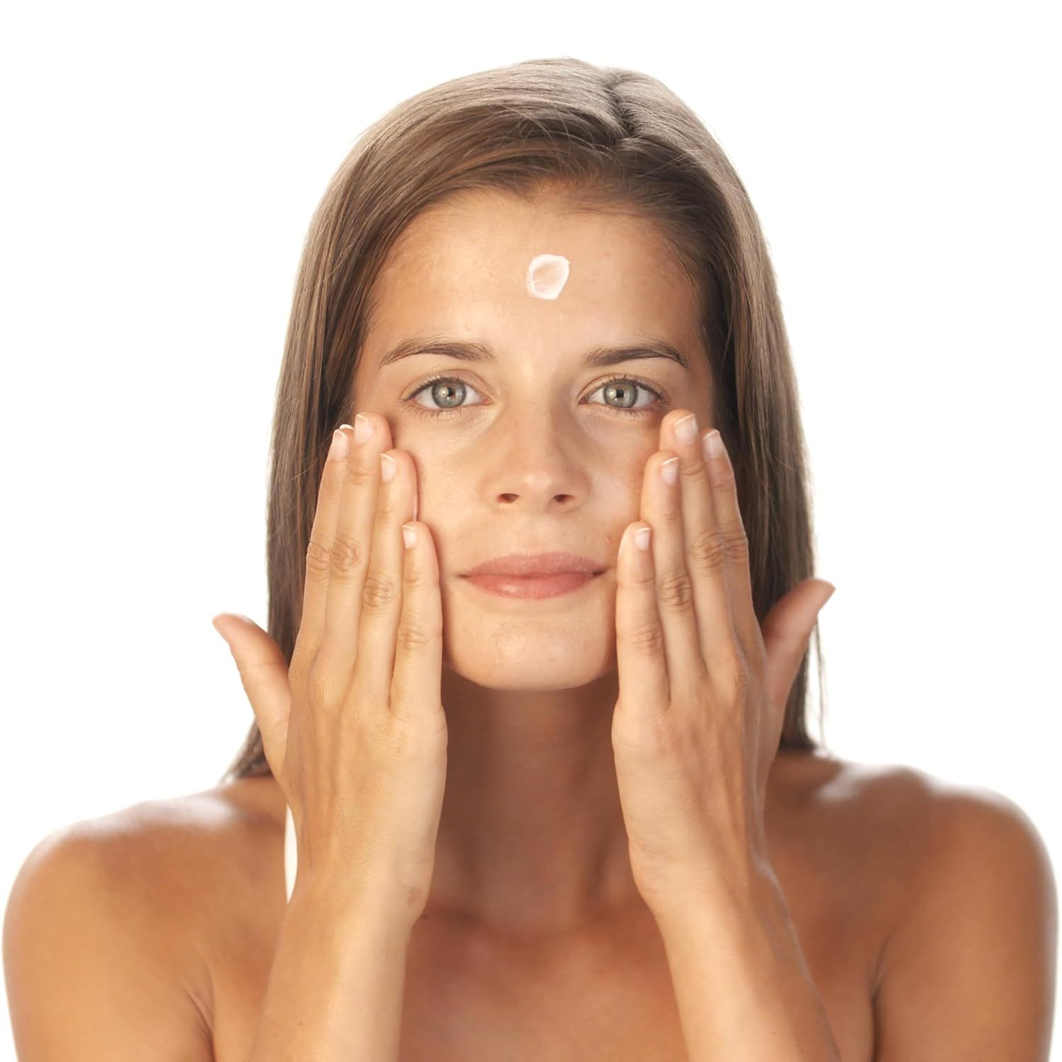 Femme appliquant de la crème sur le front.