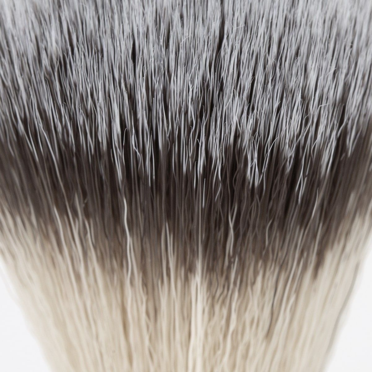 Close-up van de haren van een scheerkwast. Grijze en witte synthetische vezels.