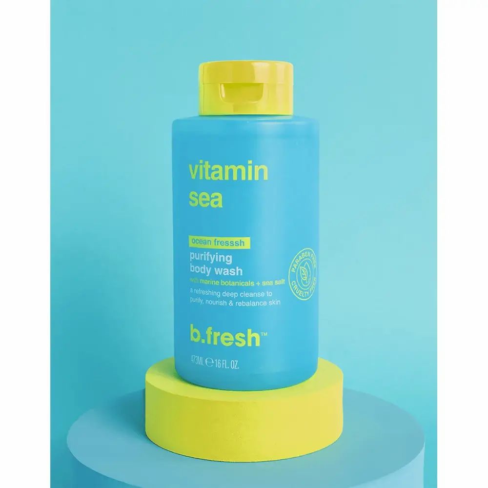 Blauw-turkoois flesje met gele dop. Opschrift: Vitamin Sea, purifying body wash, b.fresh. Flesje staat op een geel voetstuk.
