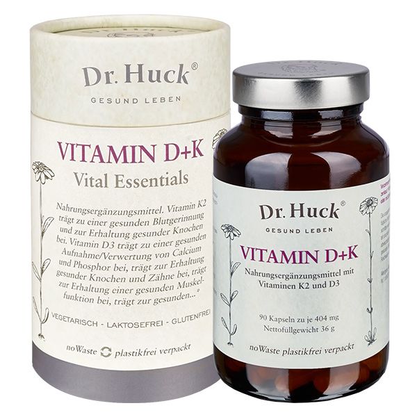 Bruine glazen fles en cilindrische verpakking met "Dr. Huck Vitamin D+K". Opschrift: "Vitamin D+K Vital Essentials".