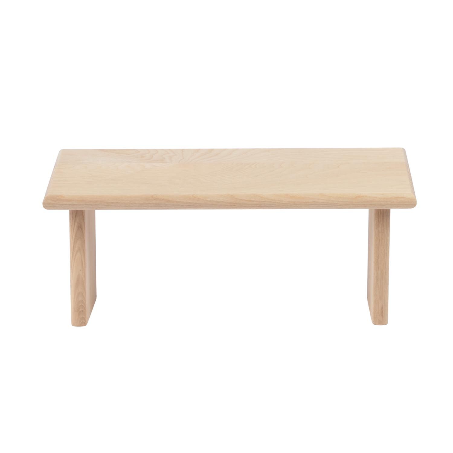 Tabouret en bois clair avec assise rectangulaire et deux pieds. Bords arrondis.