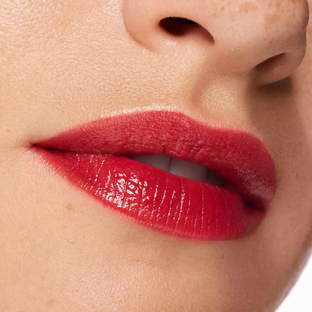 Gros plan sur des lèvres avec du rouge à lèvres rouge. Fini brillant. Teint clair.