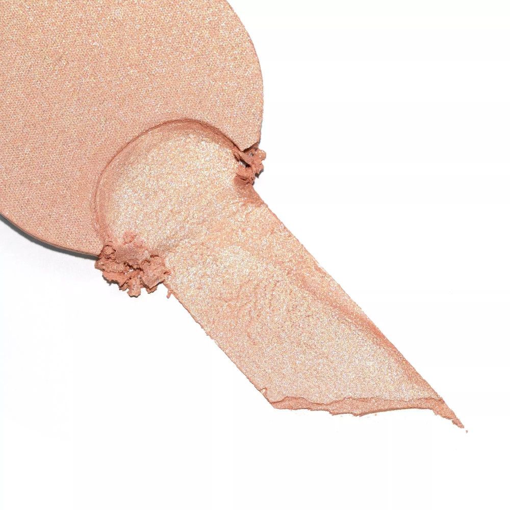 Uitgesmeerde highlighter-veeg. Lichte, goudkleurige textuur. Op witte achtergrond.