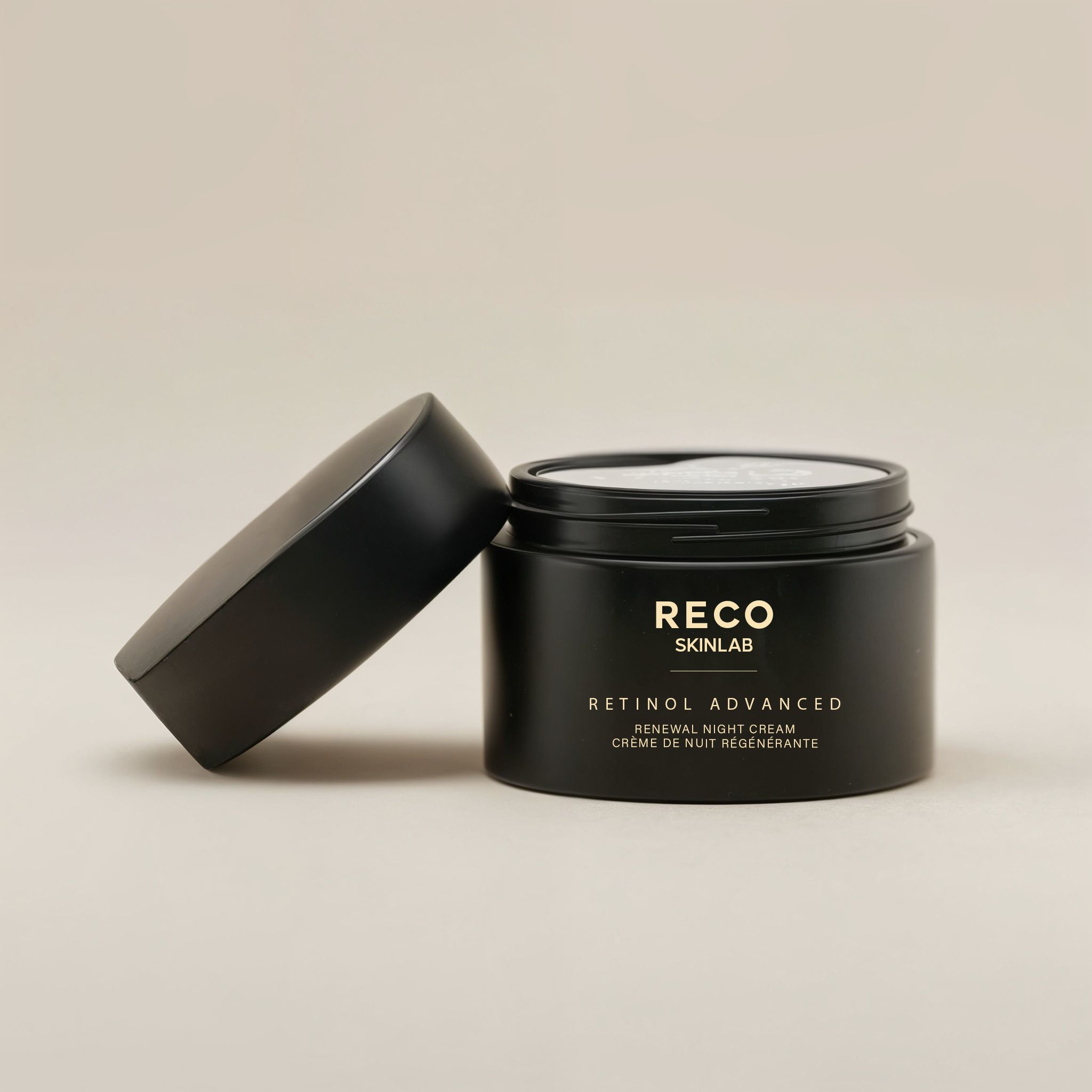 Open zwarte pot met deksel ernaast. Opschrift RECO SKINLAB, Retinol Advanced Renewal Night Cream, Crème de nuit régénérante.