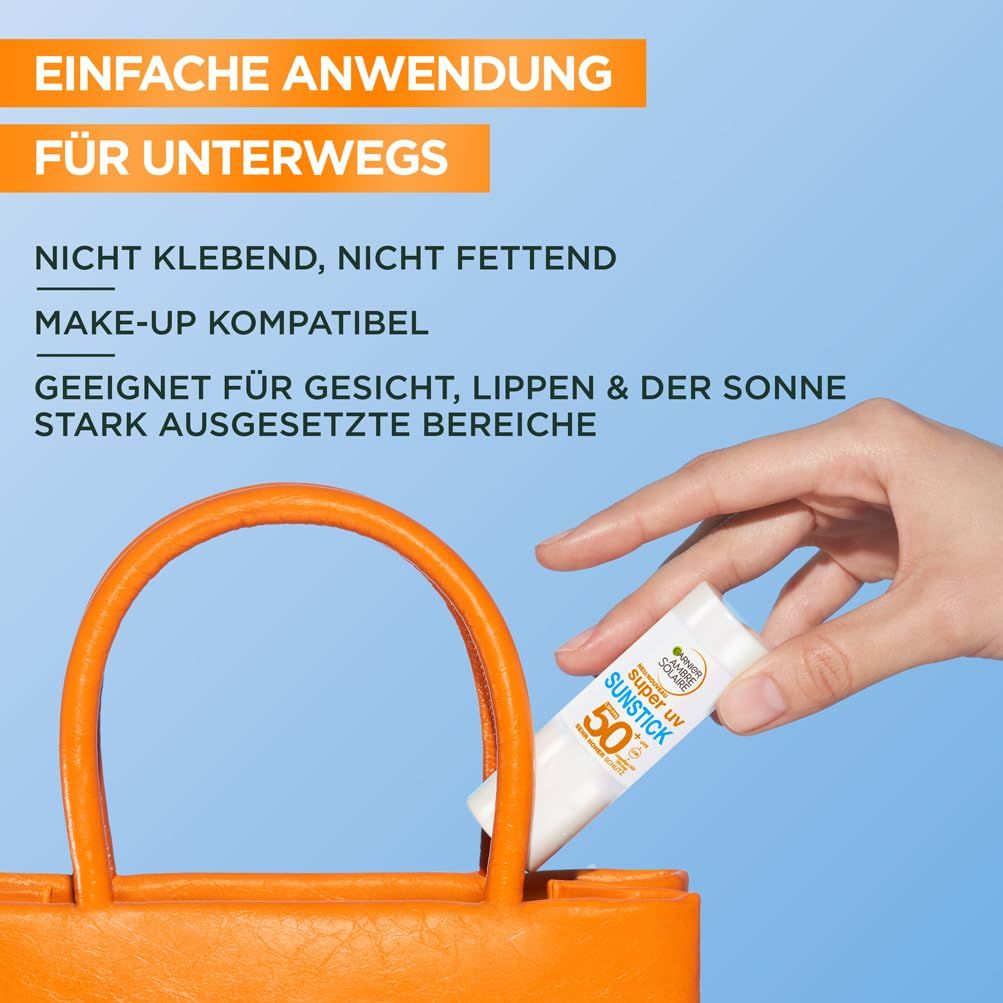 Main plaçant le stick solaire Garnier Ambre Solaire Super UV dans un sac orange. Le bâton est blanc avec lettrage bleu et vert. Texte: Application facile.