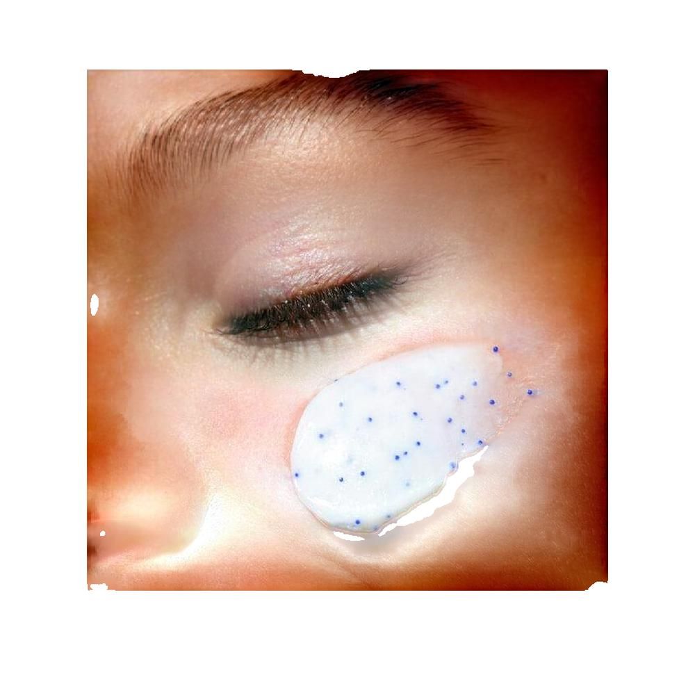 Gros plan sur un œil avec crème appliquée. Crème avec particules bleues sur la peau.