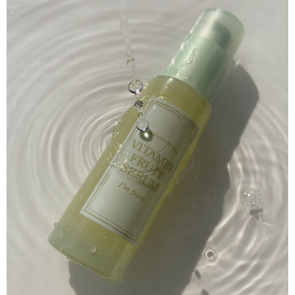 Serumfles onder water. Opschrift: Vitamin Fruit Serum, I'm from. Waterdruppels.