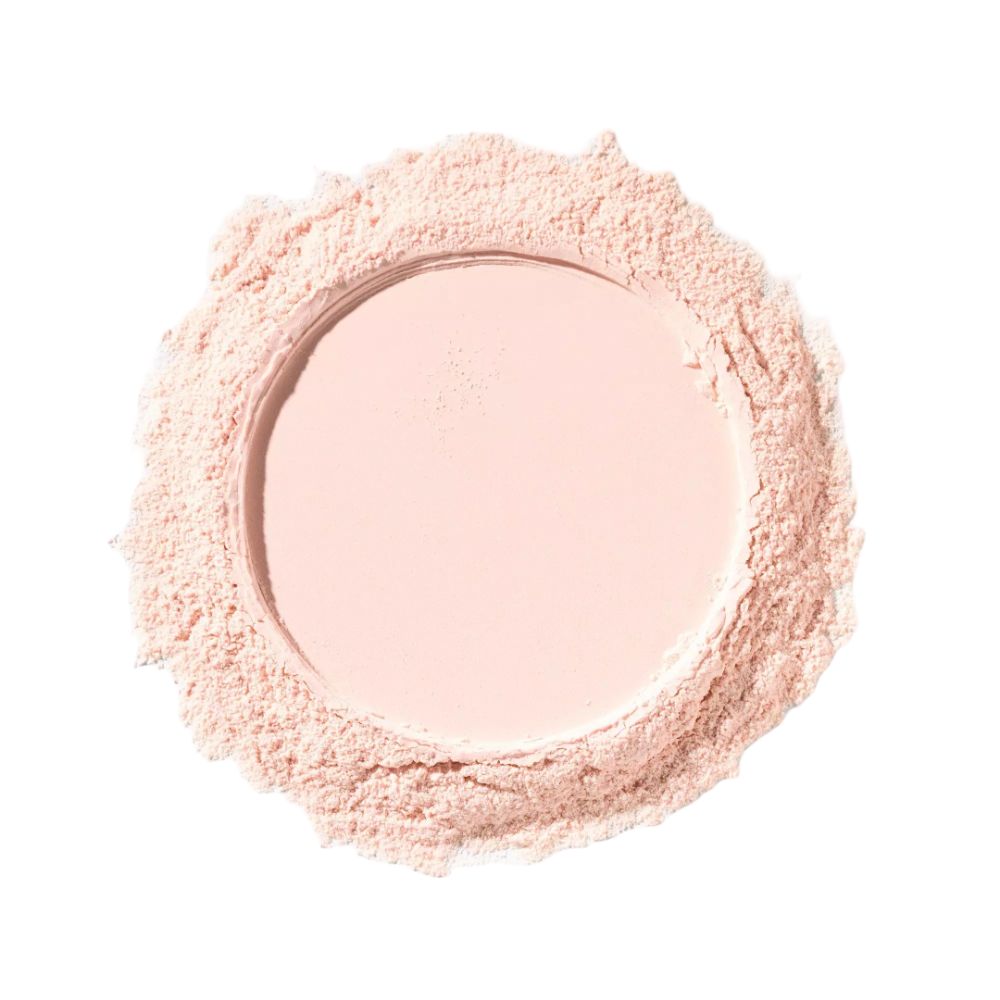 Tas de poudre rose lâche. La poudre est disposée en cercle et a une surface lisse.