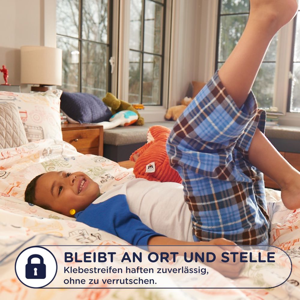Enfant sur un lit. Texte : Reste en place. Bandes adhésives fiables, sans glisser.