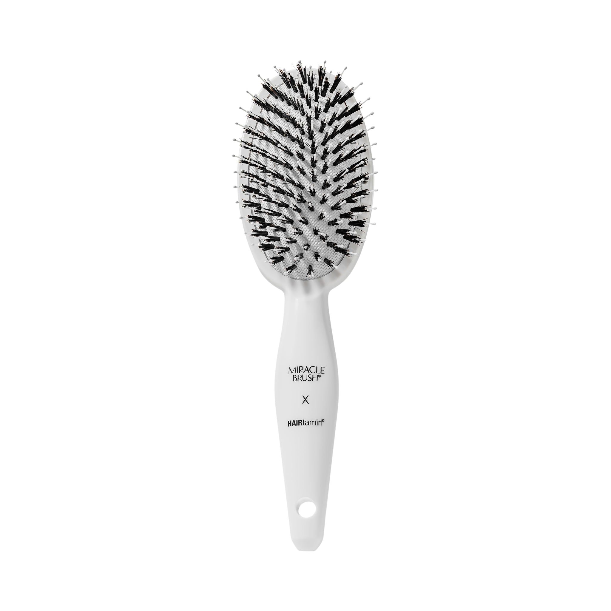 Witte ovale borstel met zwarte borstelharen. Handvat met opschrift MIRACLE BRUSH X HAIRtamin.