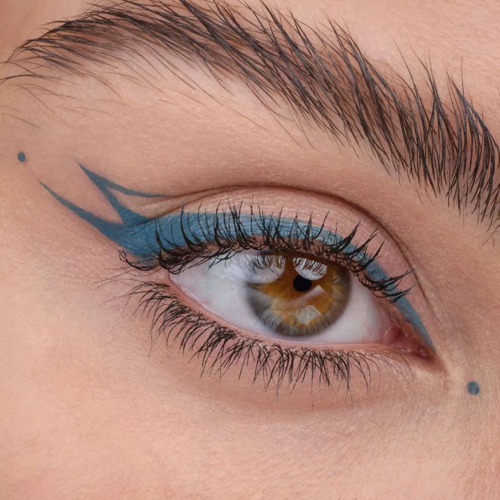 Œil avec un design d'eyeliner turquoise. Deux points au-dessus de l'œil.