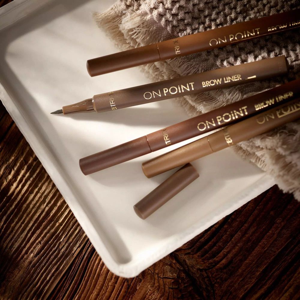 Plusieurs crayons à sourcils sur un plateau. Inscription: ON POINT BROW LINER. Différentes couleurs.