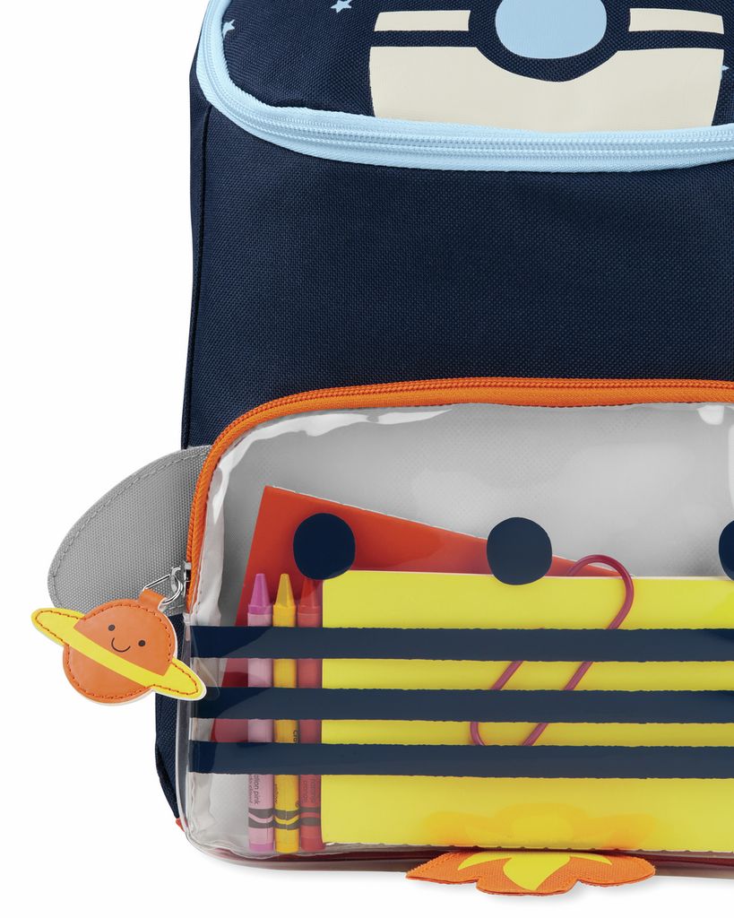 Close-up van de rugzak met transparant compartiment. Bevat potloden en papier. Het Skip Hop-logo is zichtbaar.