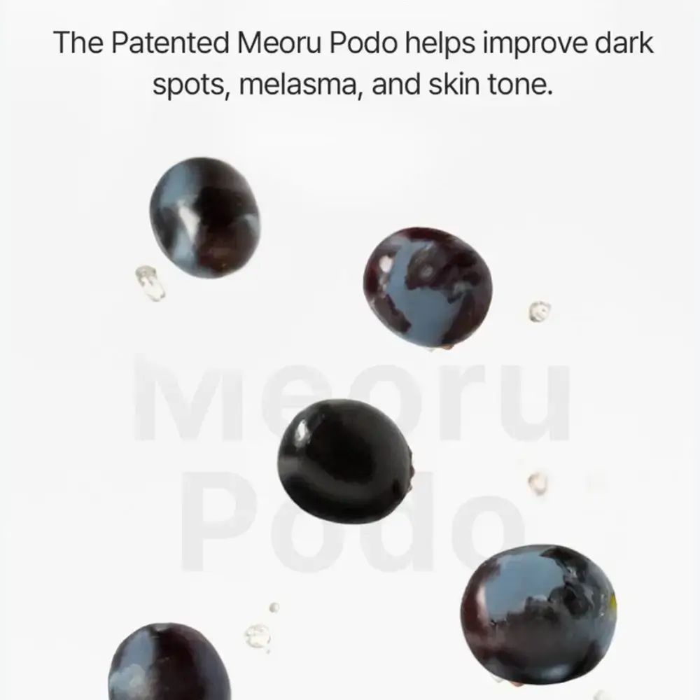 Donkere druiven en waterdruppels. Tekst: The Patented Meoru Podo helps improve dark spots, melasma, and skin tone.