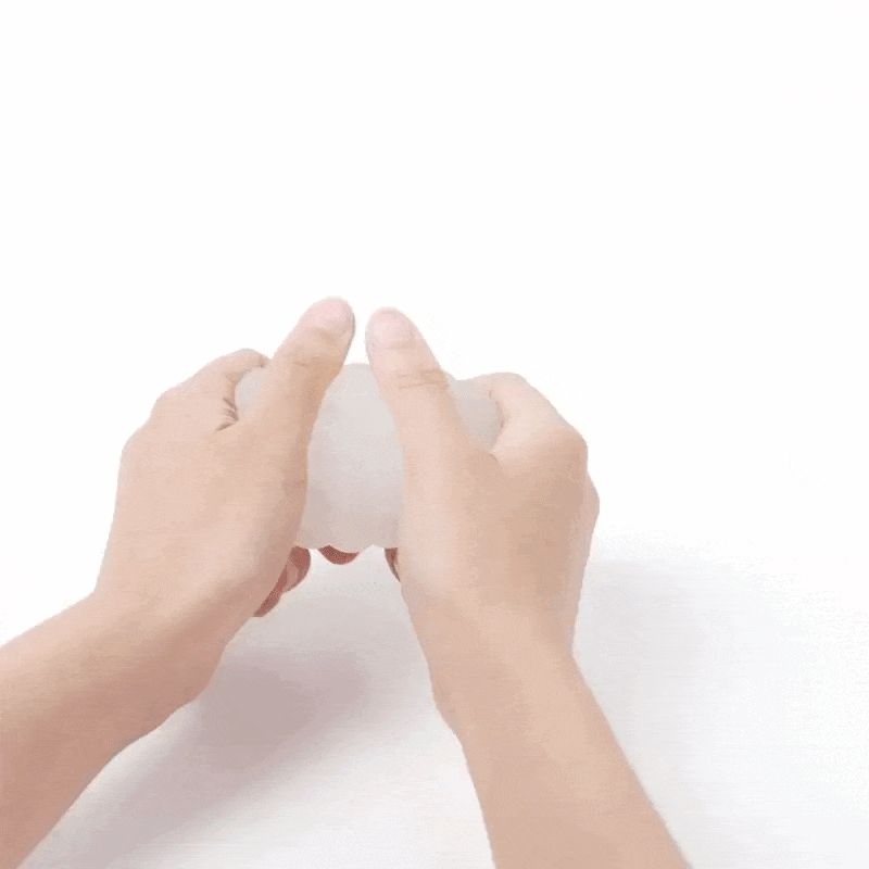 Handen houden een wit, golvend object vast. Witte achtergrond.