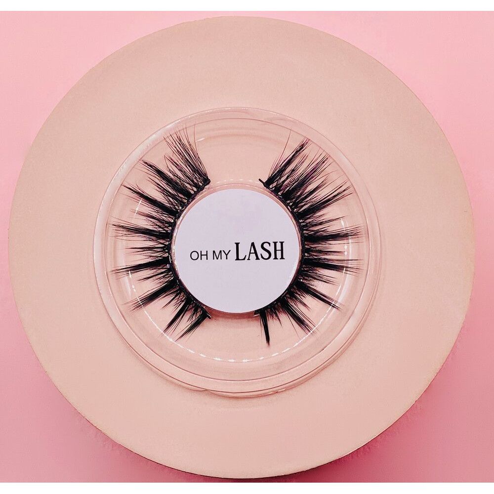 Faux cils sur fond rose. Inscription: OH MY LASH. Emballage transparent.